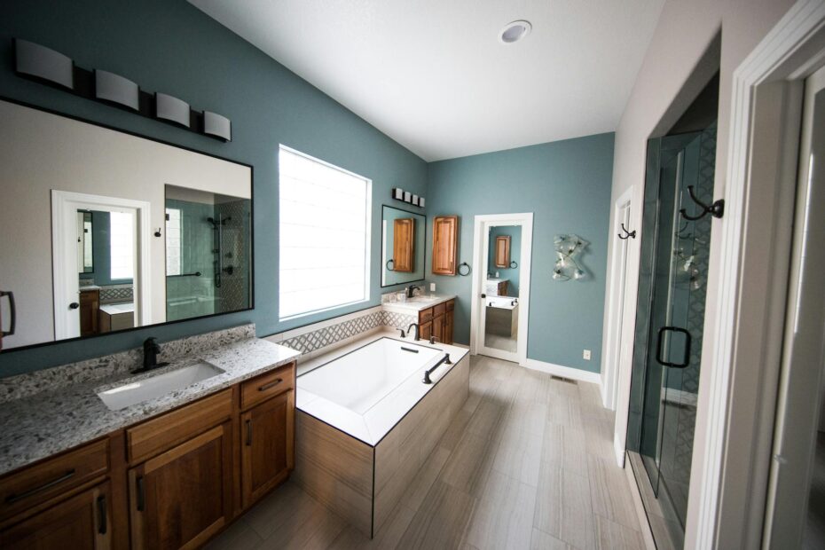 Spacious modern bathroom featuring a freestanding bathtub, wooden cabinets, and granite countertops. (Photo by Christa Grover on Pexels)