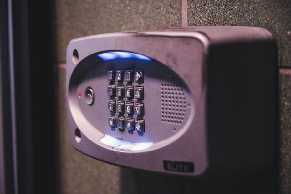 A close-up image of an illuminated security keypad mounted on a wall. (Photo by Brett Sayles on Pexels)