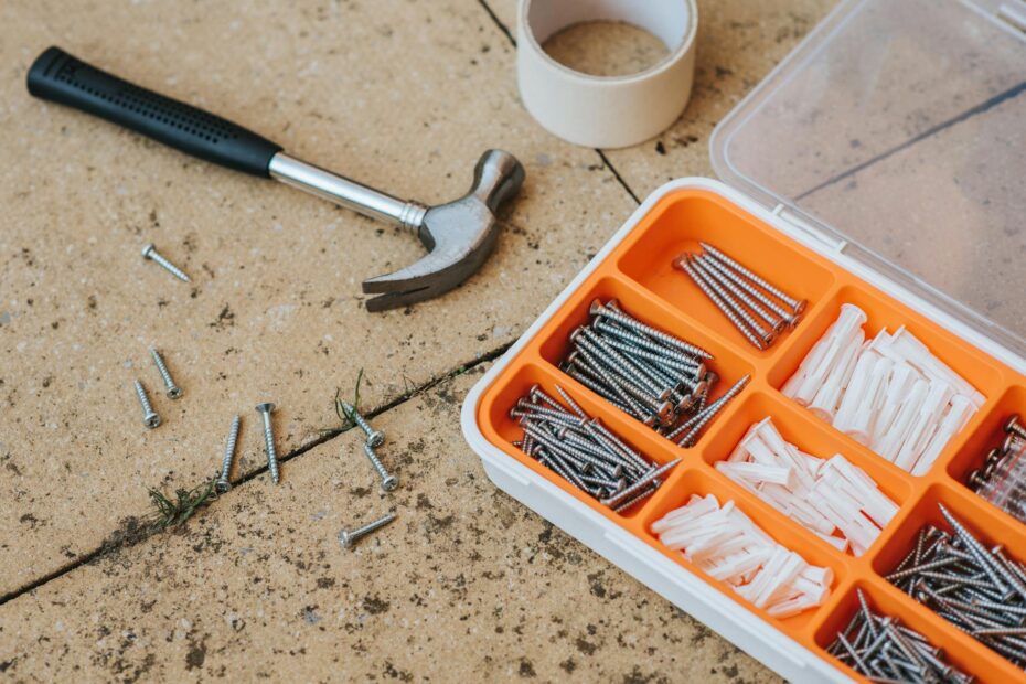 Top view of assorted repair instruments and screws in box near hammer and scotch tape on dirty ti... (Photo by Anete Lusina on Pexels)