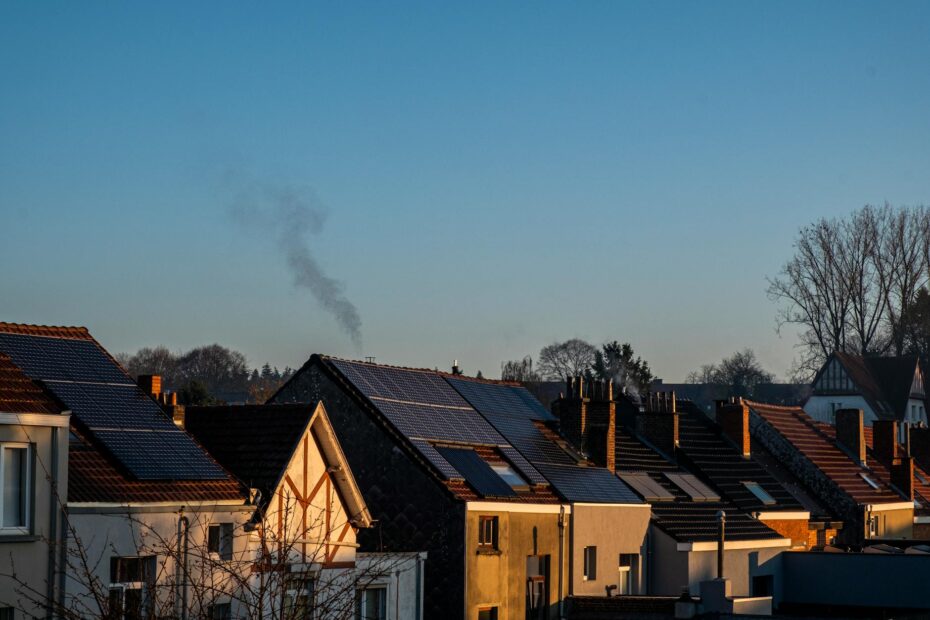 A row of houses displaying solar panels on their rooftops, reflecting sustainable energy practices. (Photo by MARIANNE RIXHON on Pexels)