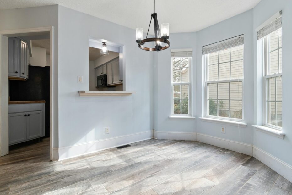 Sunlit empty room featuring a modern chandelier and wooden floors, ideal for home staging. (Photo by Curtis Adams on Pexels)