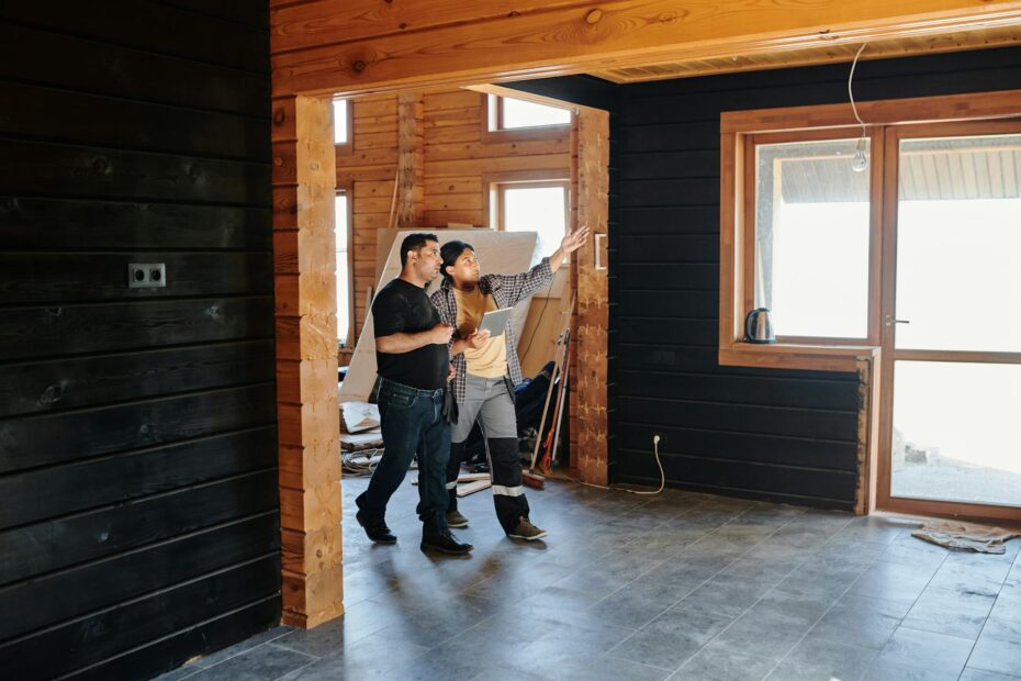 Two adults discussing home renovation in a partially constructed modern wooden interior. (Photo by Mikael Blomkvist on Pexels)
